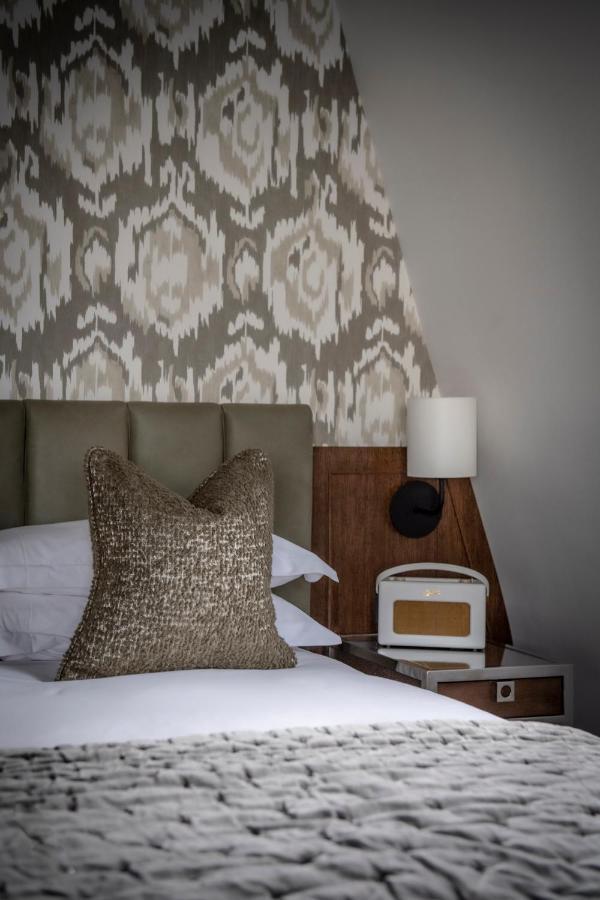 The Marylebone Hotel Londyn Zewnętrze zdjęcie A bedroom with a bed, a nightstand, a lamp, and a pillow